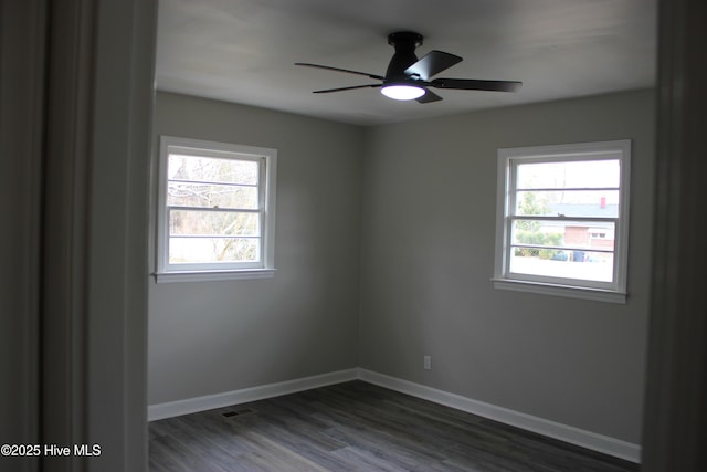 unfurnished room featuring ceiling fan, a healthy amount of sunlight, and dark hardwood / wood-style flooring