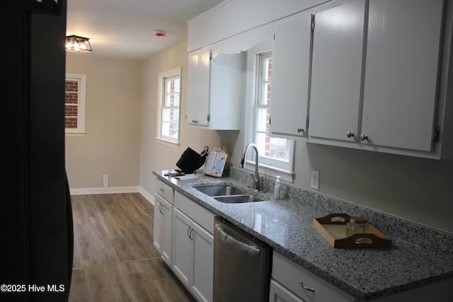 kitchen featuring sink, light stone counters, light hardwood / wood-style floors, white cabinets, and stainless steel dishwasher