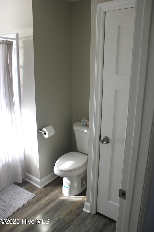 bathroom featuring hardwood / wood-style flooring and toilet