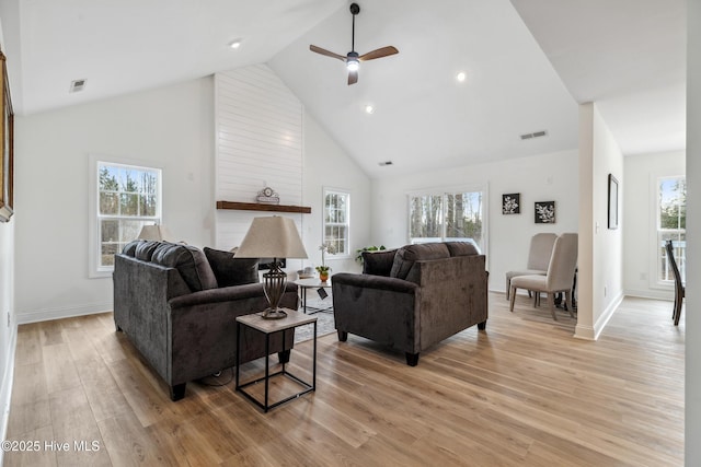 living room featuring ceiling fan, plenty of natural light, high vaulted ceiling, and light hardwood / wood-style floors