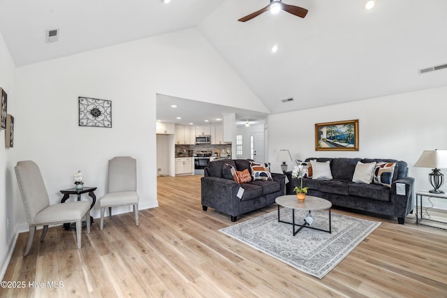 living room with high vaulted ceiling, light hardwood / wood-style floors, and ceiling fan