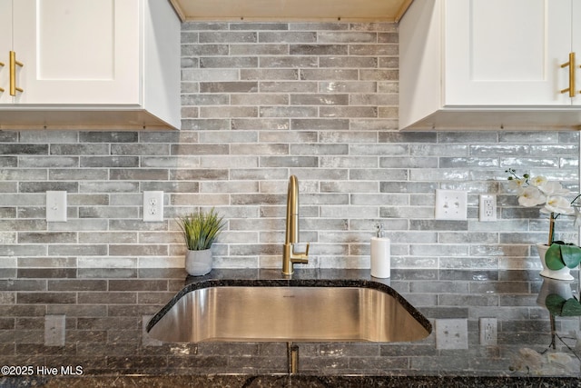 kitchen with sink, decorative backsplash, dark stone counters, and white cabinets