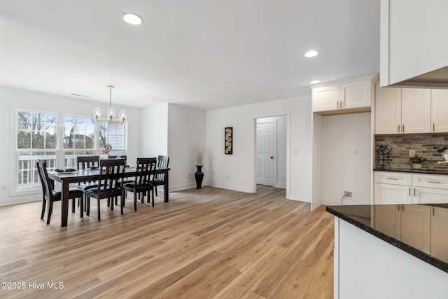 dining area with a chandelier and light hardwood / wood-style floors