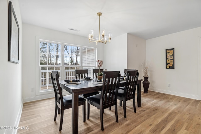 dining space featuring a chandelier and light wood-type flooring