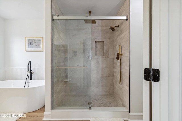 bathroom featuring hardwood / wood-style floors and shower with separate bathtub