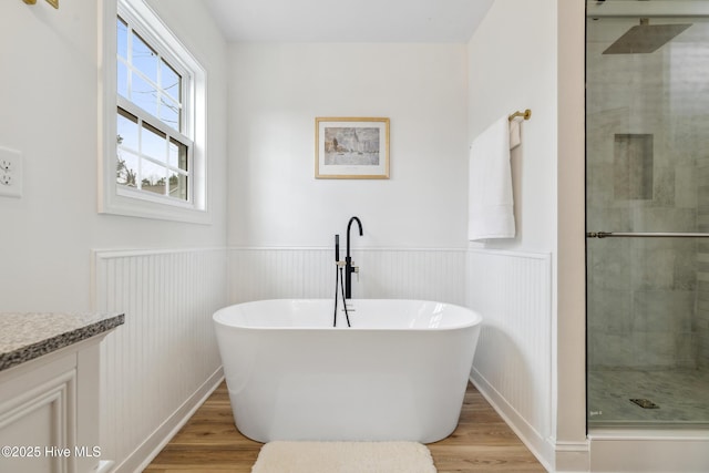 bathroom with hardwood / wood-style flooring, shower with separate bathtub, and vanity