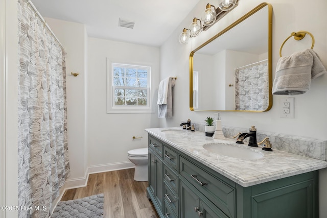 bathroom with hardwood / wood-style flooring, vanity, and toilet