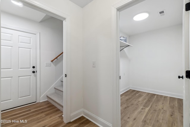 walk in closet with light hardwood / wood-style floors