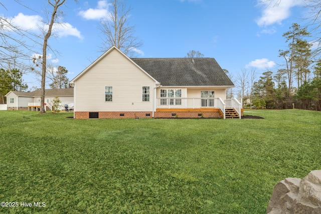 rear view of house featuring a wooden deck and a lawn