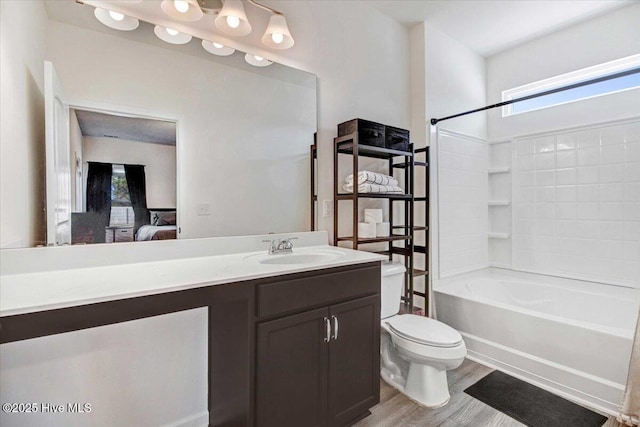 full bathroom with vanity, bathtub / shower combination, hardwood / wood-style floors, and toilet