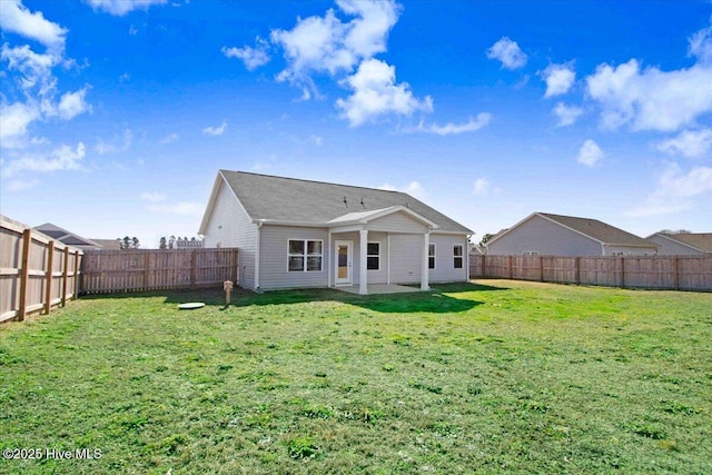 rear view of house with a yard and a patio