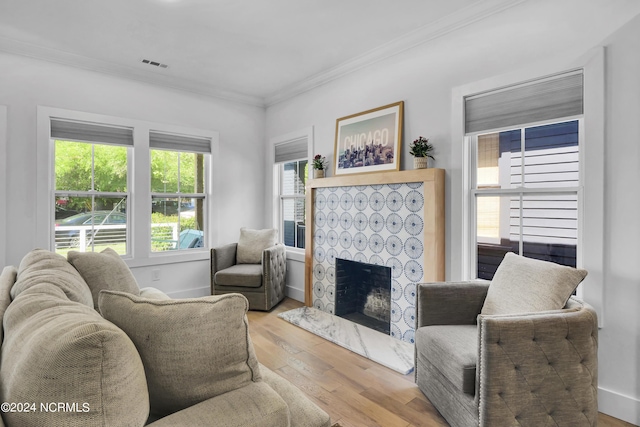 living room with ornamental molding, a premium fireplace, and light wood-type flooring