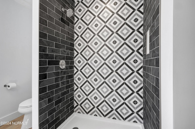 bathroom with tiled shower and toilet