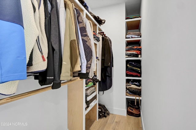 walk in closet with light hardwood / wood-style flooring