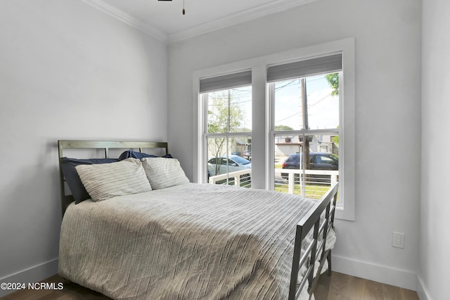 bedroom featuring wood-type flooring and ornamental molding