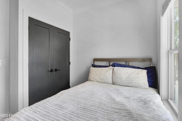 bedroom with ornamental molding and a closet