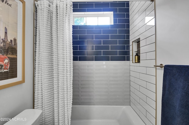 bathroom featuring shower / tub combo and toilet