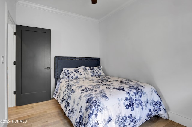 bedroom with crown molding, wood-type flooring, and ceiling fan