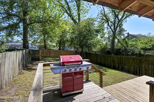 wooden deck with area for grilling and a lawn