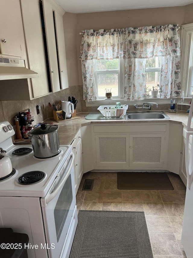 kitchen with white cabinetry, a healthy amount of sunlight, sink, and electric range