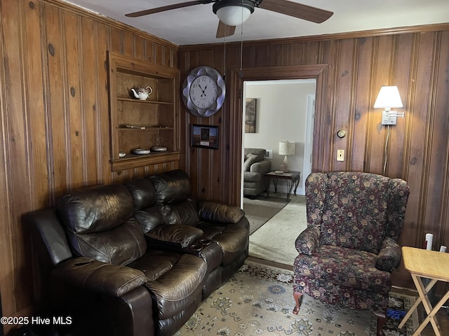 living room featuring ceiling fan and wooden walls