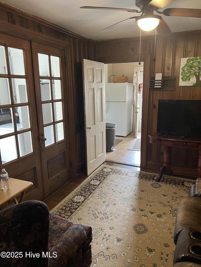 interior space featuring wooden walls, french doors, and ceiling fan