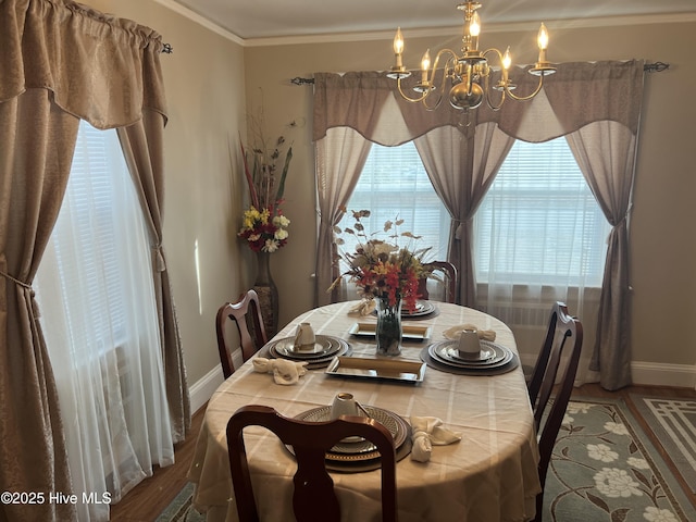 dining area with crown molding, a wealth of natural light, a chandelier, and hardwood / wood-style flooring