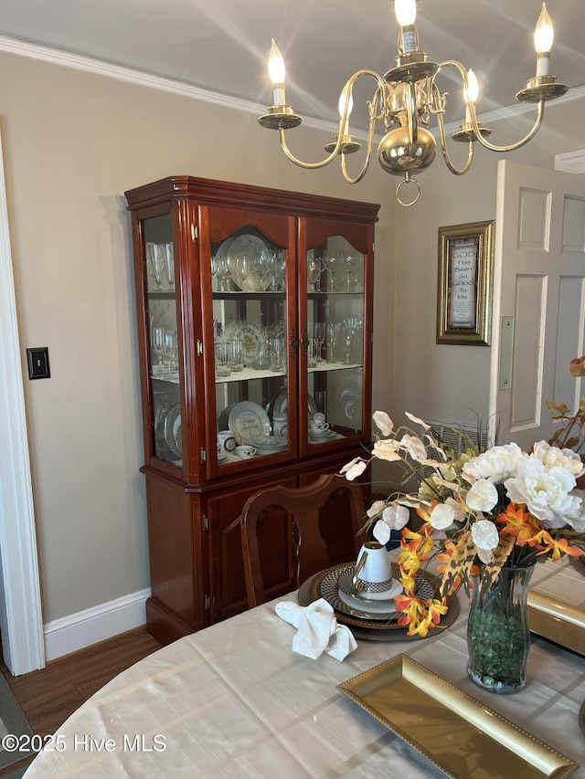 dining room featuring a notable chandelier, ornamental molding, and dark hardwood / wood-style floors