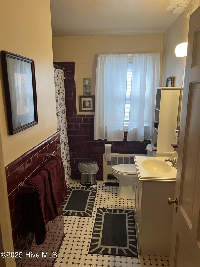 bathroom with tile walls, vanity, tile patterned flooring, and toilet