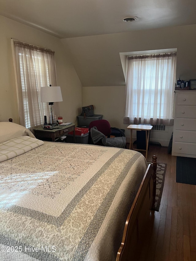 bedroom with vaulted ceiling and dark hardwood / wood-style floors