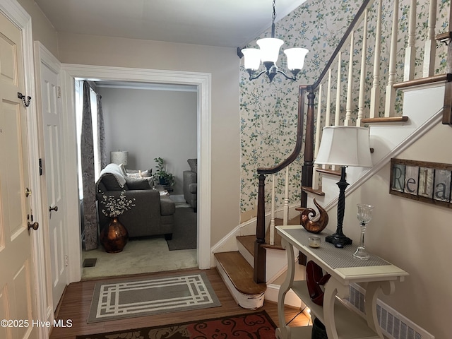 foyer with wood-type flooring and a chandelier