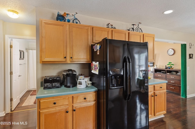 kitchen featuring dark hardwood / wood-style floors, a textured ceiling, and black fridge