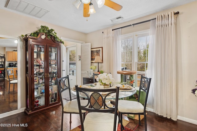 dining space featuring ceiling fan, dark wood-type flooring, and a textured ceiling