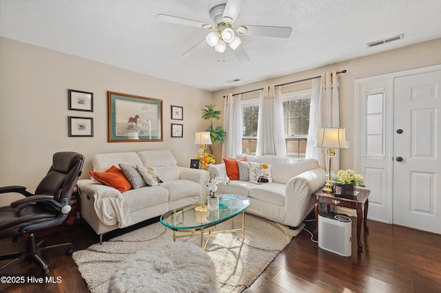 living room featuring a textured ceiling, dark hardwood / wood-style floors, and ceiling fan