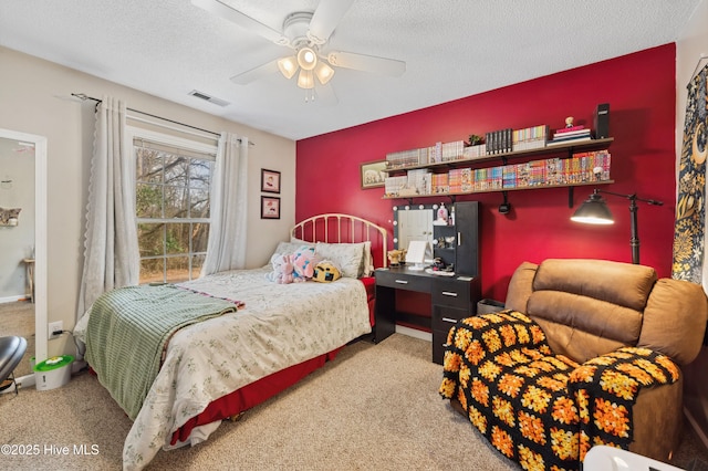 carpeted bedroom with ceiling fan and a textured ceiling