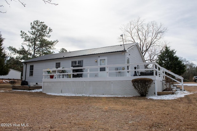 rear view of property featuring a deck and a lawn