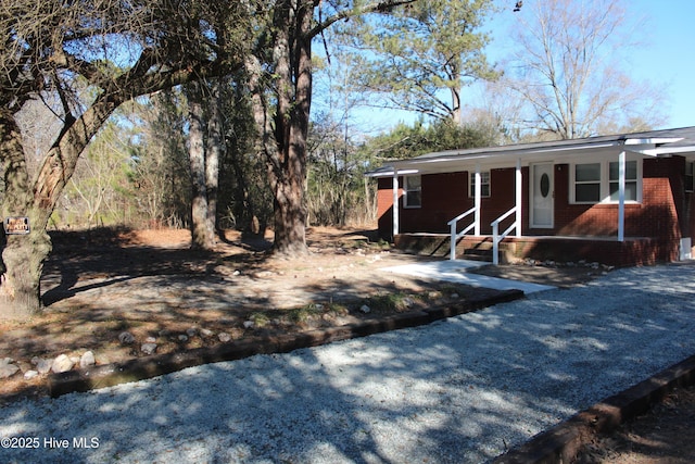 view of front facade with brick siding and a porch