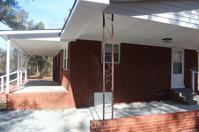view of side of property featuring brick siding, entry steps, and crawl space