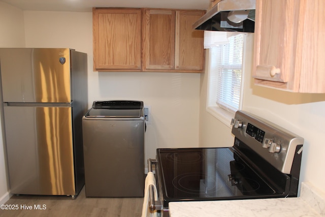 kitchen with washer / clothes dryer, appliances with stainless steel finishes, wood finished floors, light countertops, and under cabinet range hood