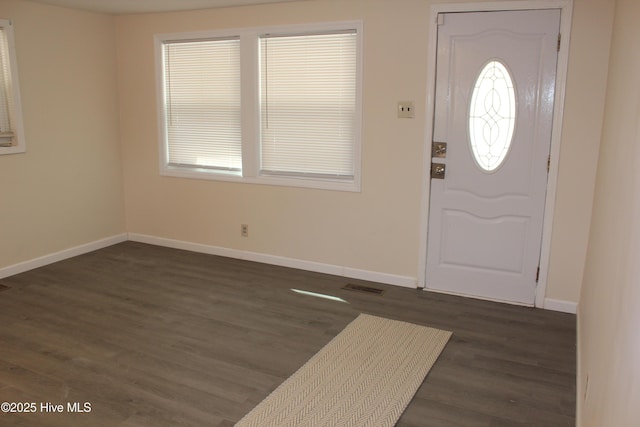 entryway with dark wood-style flooring, baseboards, visible vents, and a wealth of natural light
