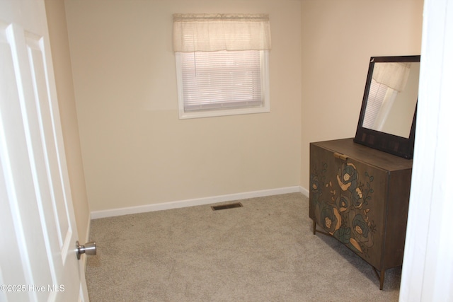 unfurnished bedroom with carpet flooring, visible vents, and baseboards