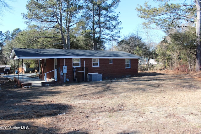 rear view of property with brick siding, a porch, and central AC