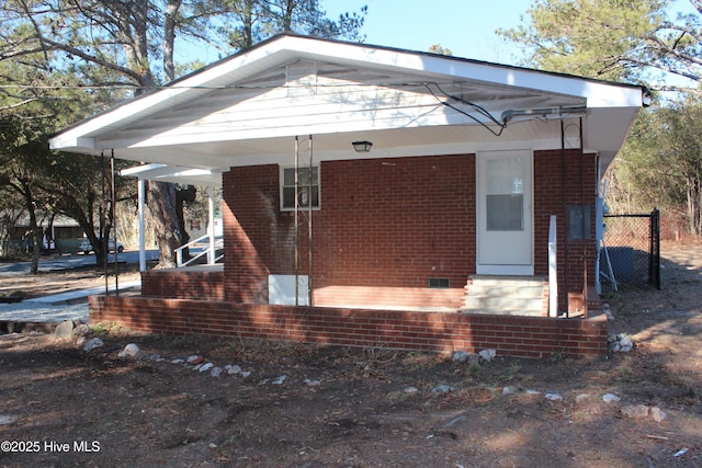 bungalow-style house with brick siding, fence, and crawl space
