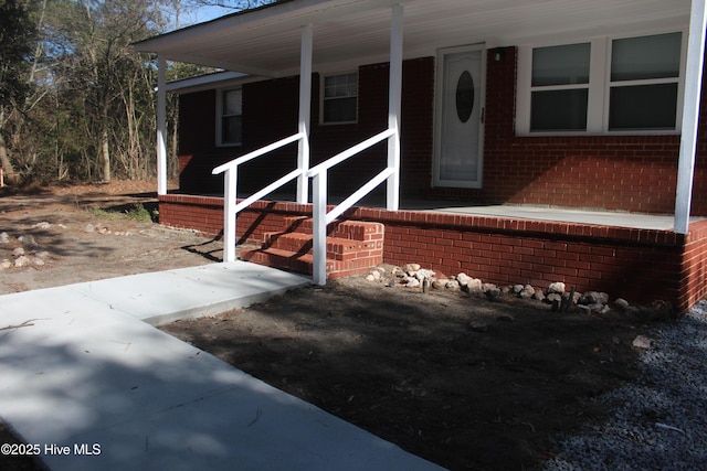 view of front of house with covered porch and brick siding