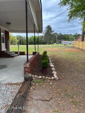 view of yard featuring entry steps and fence