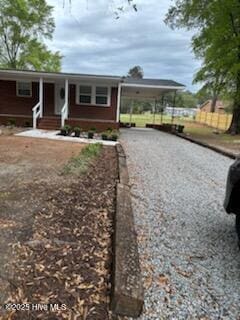 view of front of property featuring a carport, entry steps, and driveway