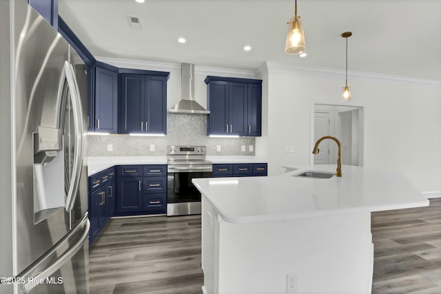 kitchen with blue cabinetry, a sink, appliances with stainless steel finishes, wall chimney exhaust hood, and tasteful backsplash