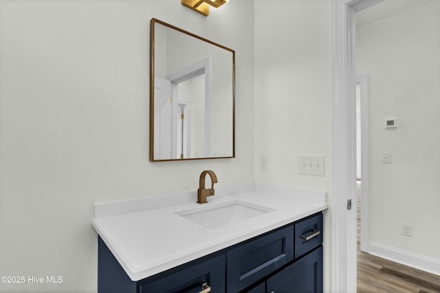 bathroom with baseboards, wood finished floors, and vanity