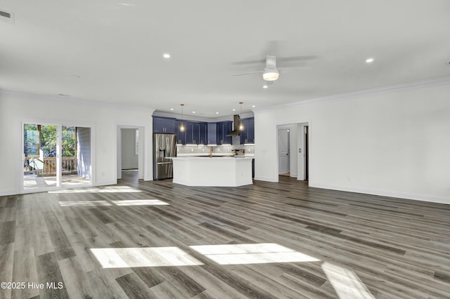 unfurnished living room featuring ornamental molding, a ceiling fan, wood finished floors, recessed lighting, and baseboards