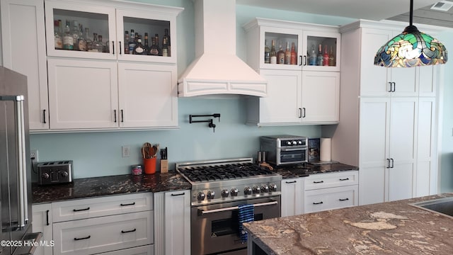 kitchen featuring high end appliances, white cabinetry, and custom exhaust hood